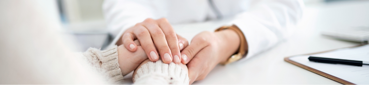 A woman's hands clasped over another female's hands